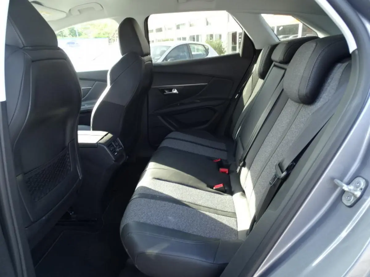Vue intérieure côté droit des sièges arrière du Peugeot 3008 gris Artense, tissu et cuir, avec ceinture de sécurité visible.