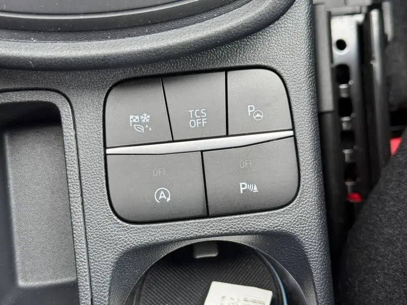 Gros plan sur les boutons de commande du tableau de bord du Ford Puma 2024, finition ST-Line, avec surface noire texturée.