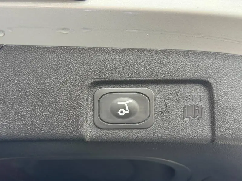Bouton noir de fermeture électrique du hayon sur le bord intérieur du coffre du Ford Puma 2024 finition ST-Line.