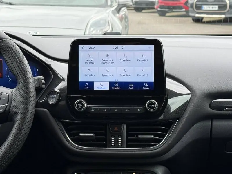 Vue centrale du tableau de bord noir du Ford Puma 2024 ST-Line avec écran tactile et commandes audio visibles.