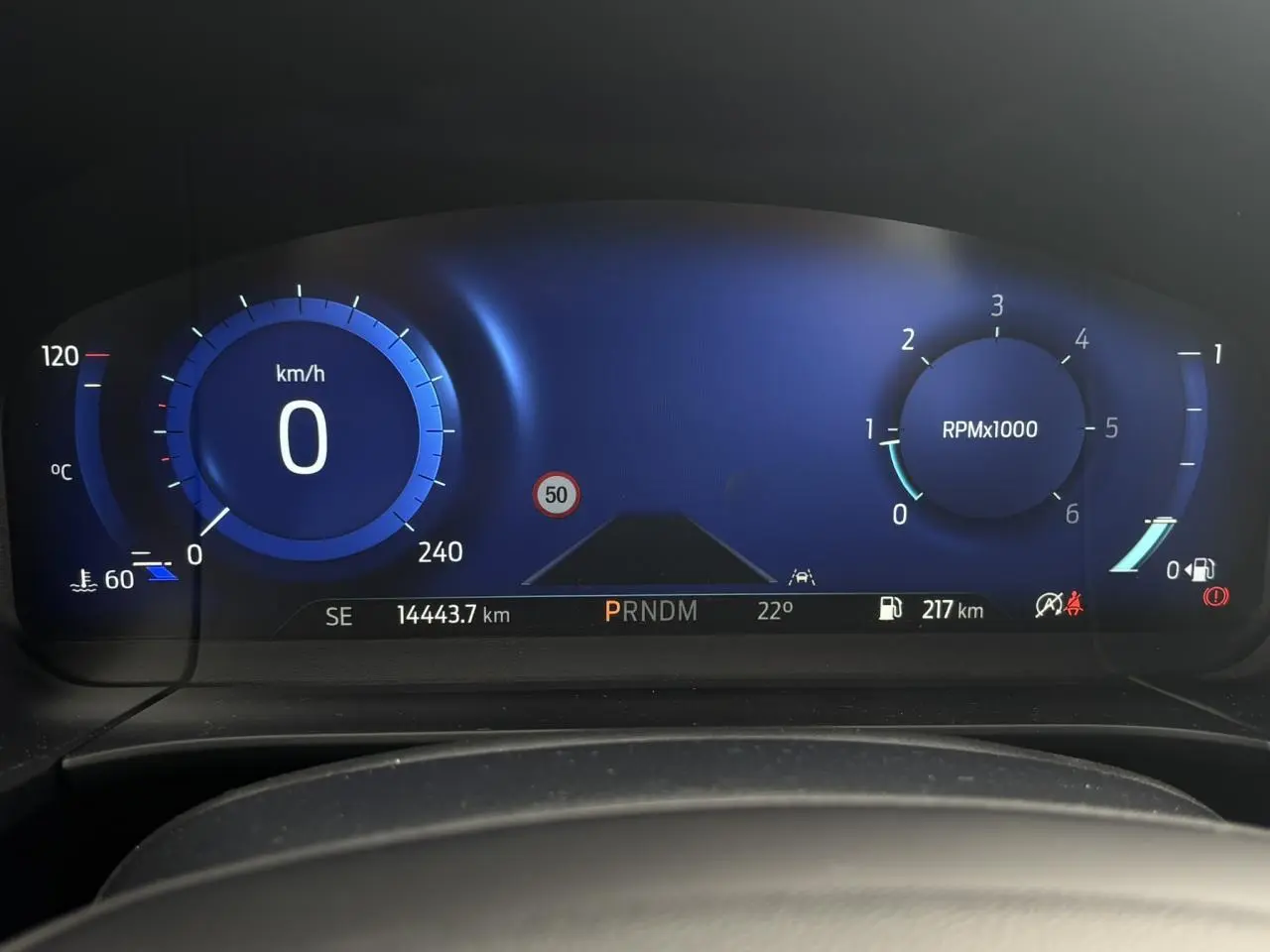 Combiné d'instrumentation numérique bleu affichant vitesse, régime moteur et informations de conduite du Ford Kuga 2023.