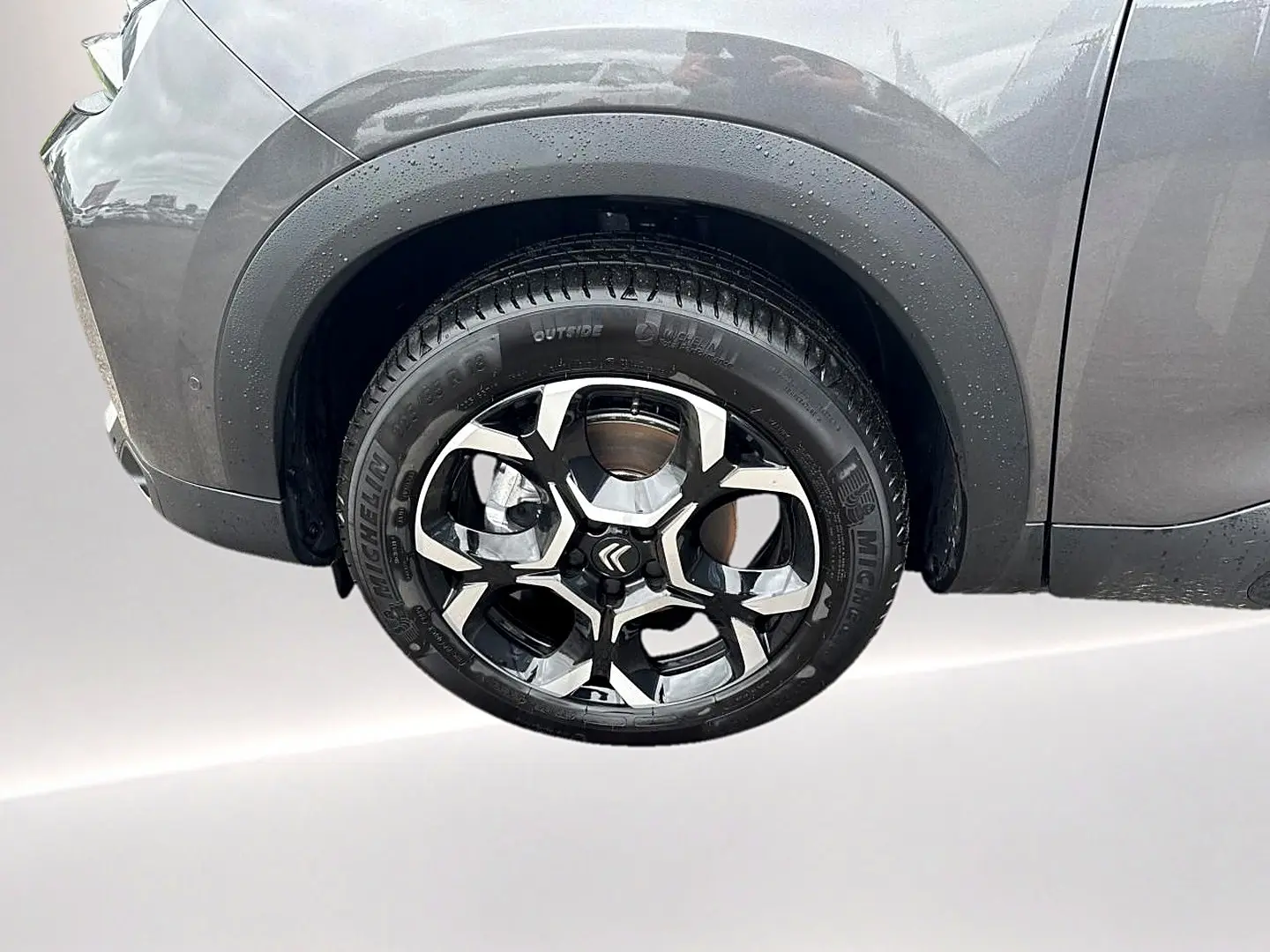 Gros plan sur la roue avant droite du Citroën C5 Aircross gris platinium avec jante alliage noire et argentée.
