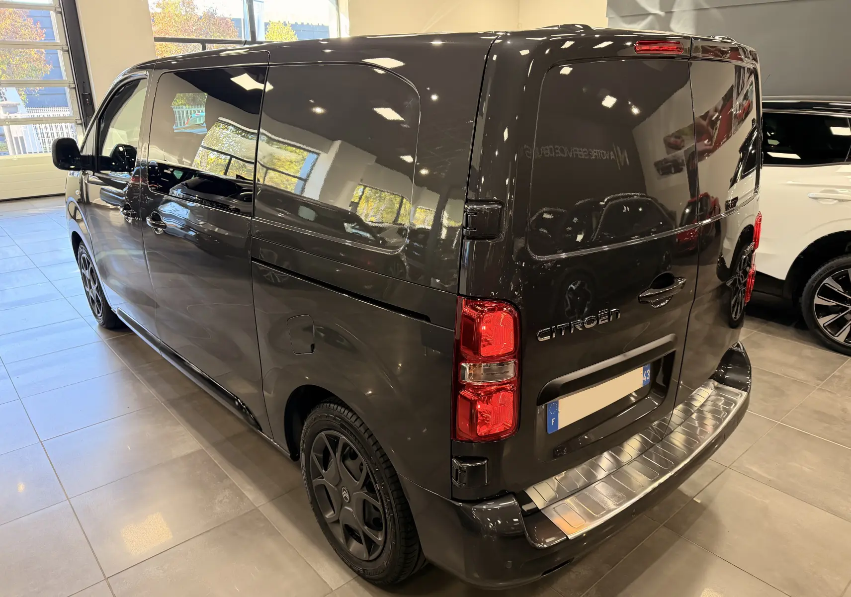 Vue 3/4 arrière droite du Citroën Jumpy Cabine Approfondie gris Titanium 2025 avec porte latérale coulissante et feux arrière rouges.