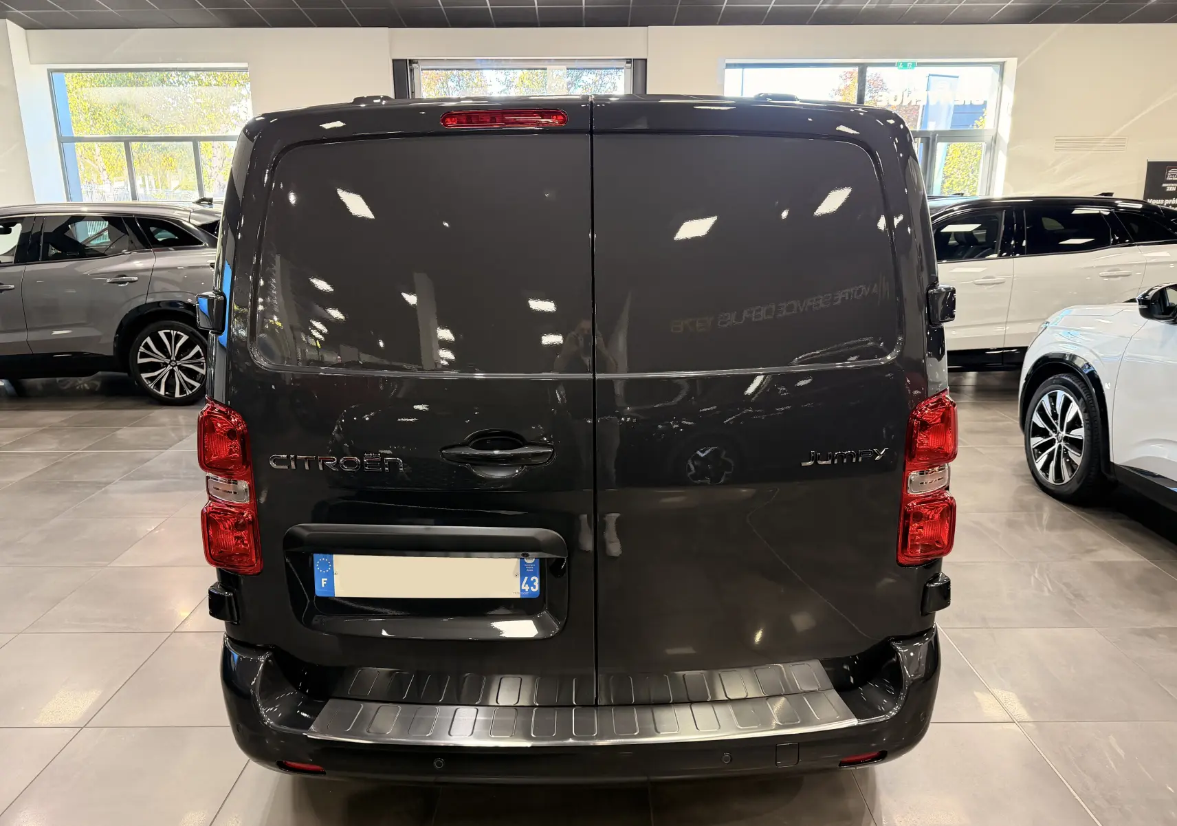 Vue arrière d'un Citroën Jumpy Cabine Approfondie gris Titanium, portes battantes fermées en intérieur showroom.
