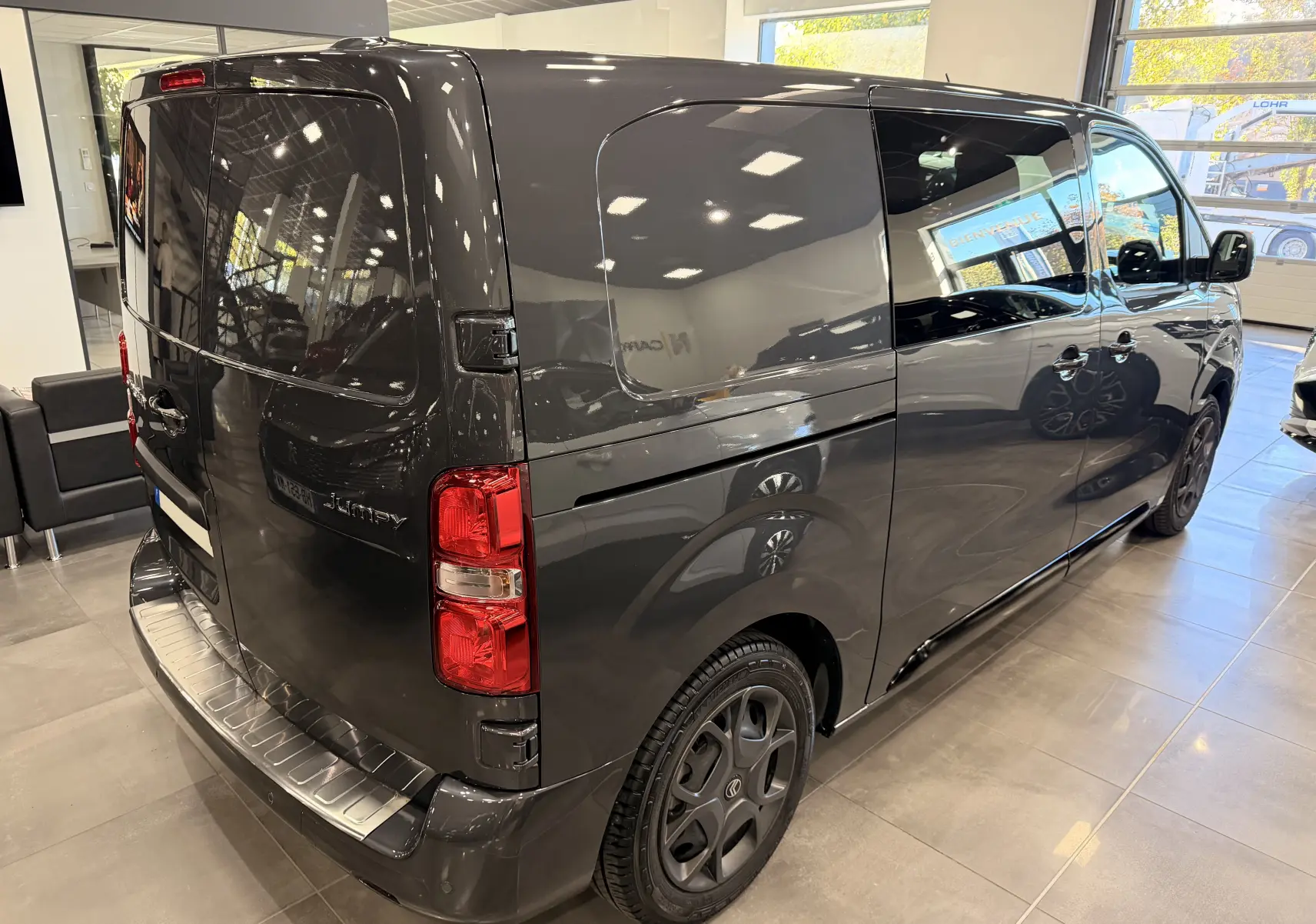 Vue 3/4 arrière droite du Citroën Jumpy Cabine Approfondie gris titanium avec porte latérale coulissante en showroom.