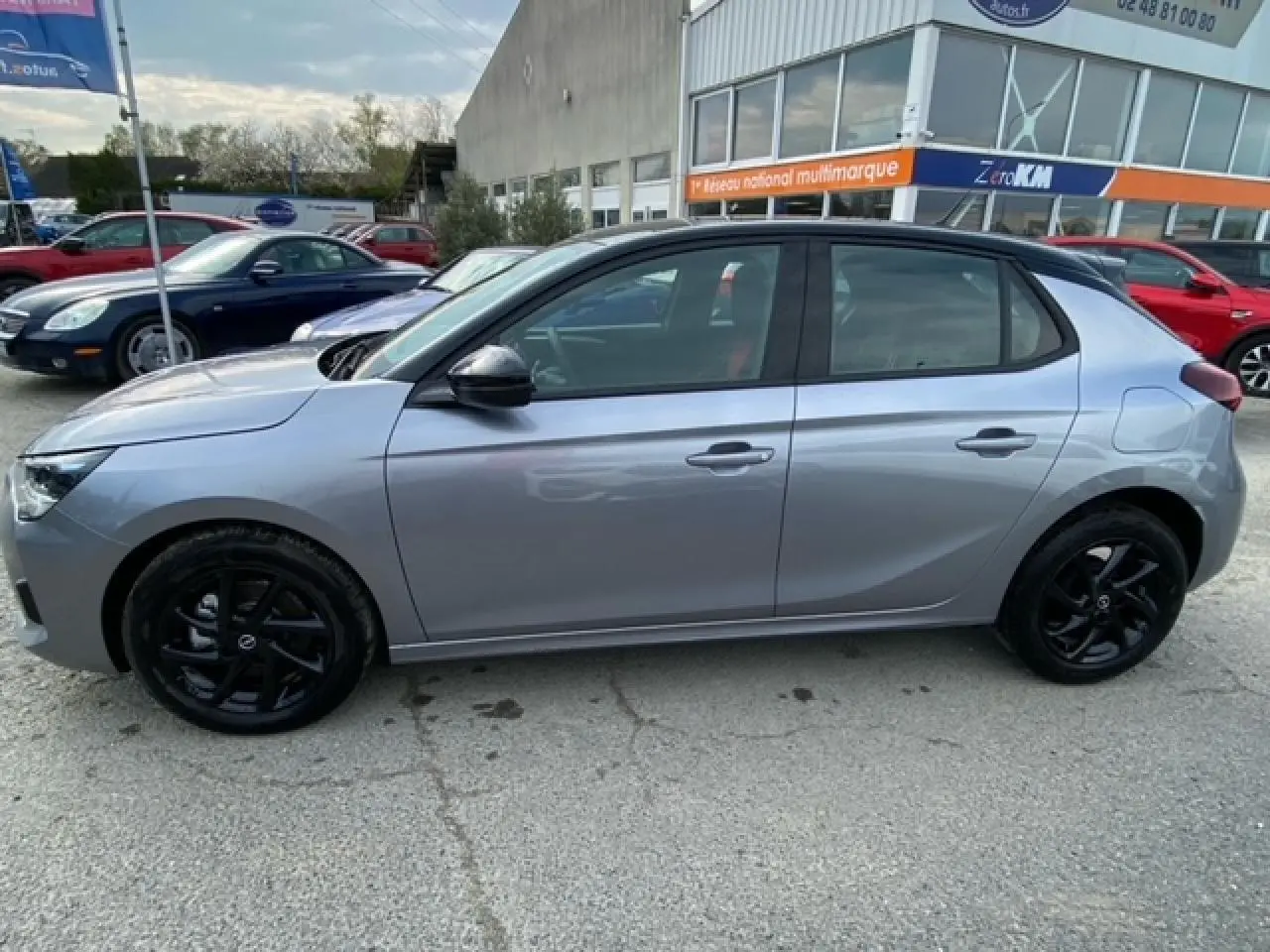 Opel Corsa gris magnetic vue de profil côté gauche, avec toit noir et jantes alliage noires brillantes.
