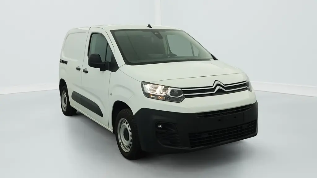 Fourgon Citroën Berlingo blanc Banquise vu en 3/4 avant droit avec jantes tôles grises et projecteurs allumés.