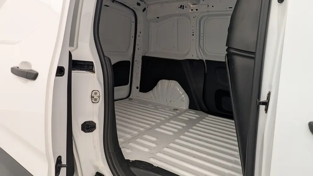 Vue intérieure de la zone de chargement du Citroën Berlingo Fourgon blanc banquise avec porte latérale coulissante droite ouverte.