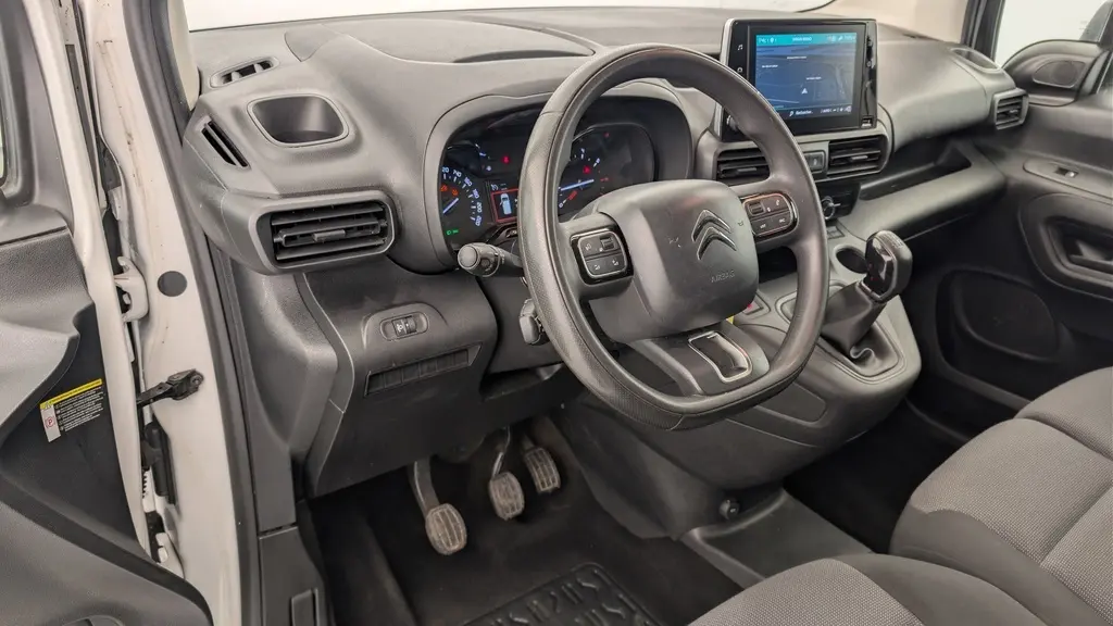 Vue intérieure côté conducteur du Citroën Berlingo Van blanc, avec tableau de bord noir et écran tactile central.