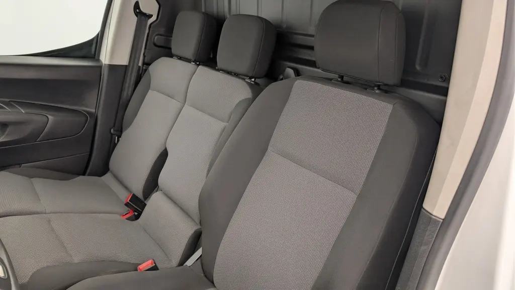 Vue intérieure côté conducteur du Citroën Berlingo Fourgon 2020, sièges tissu gris Mica et cloison cabine noire.