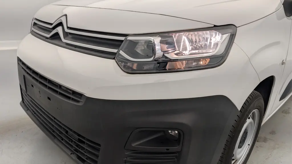 Vue 3/4 avant droit du Citroën Berlingo Van blanc Banquise avec phares allumés et pare-chocs noir mat.