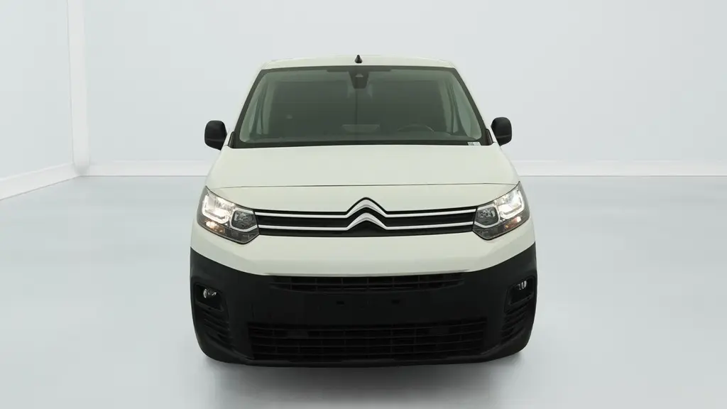 Vue frontale du Citroën Berlingo Van M 650 BlueHDi 100 blanc Banquise avec pare-chocs noir et projecteurs allumés.