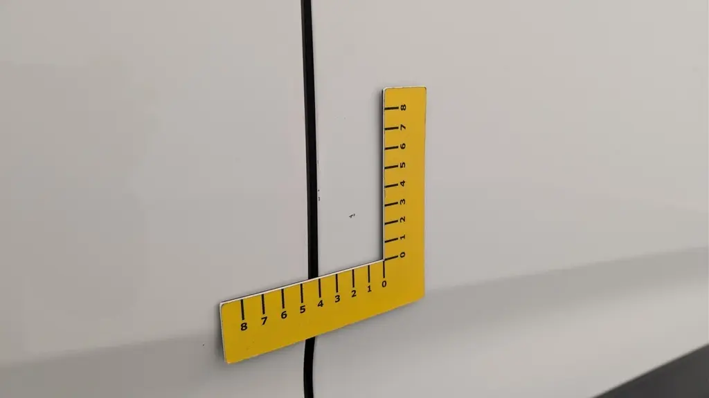 Gros plan sur une rayure fine sur la porte blanche banquise du Citroën Berlingo Fourgon côté droit.