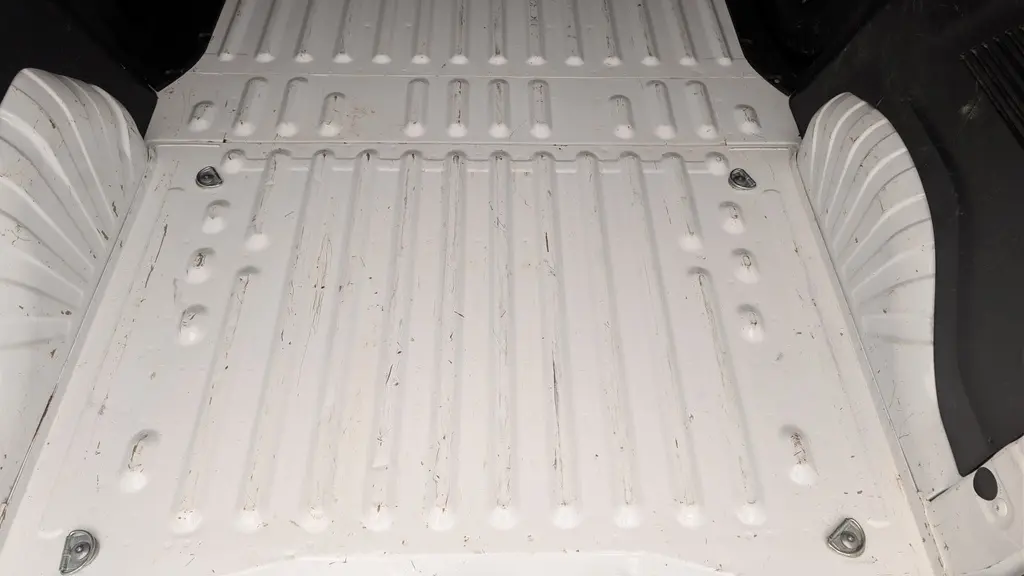 Vue plongeante sur la zone de chargement blanche du Citroën Berlingo Fourgon avec anneaux d'arrimage au sol visibles.