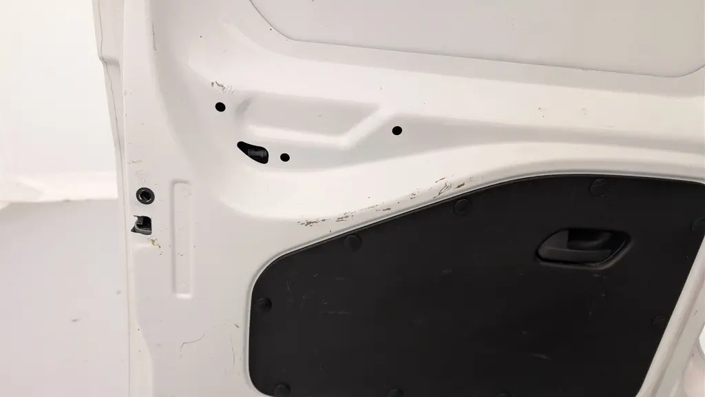 Gros plan sur la porte arrière gauche blanche Banquise du Citroën Berlingo Fourgon 2020 avec panneau intérieur noir et poignée intégrée.