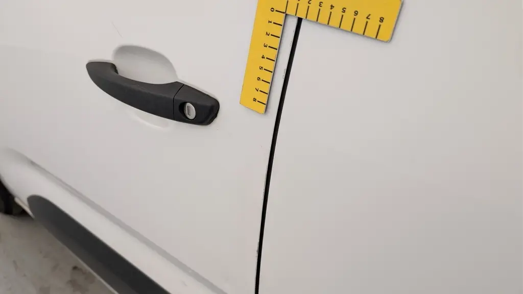 Gros plan sur la poignée de porte noire côté droit du Citroën Berlingo Fourgon blanc Banquise 2020.