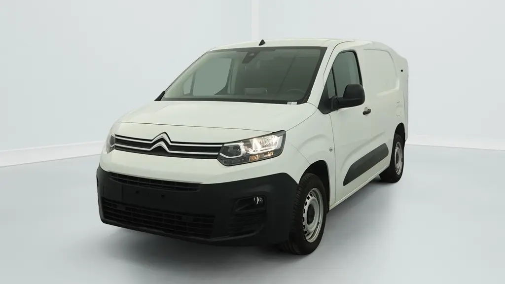 Citroën Berlingo Van blanc banquise vu de 3/4 avant droit avec projecteurs allumés et jantes tôles grises.