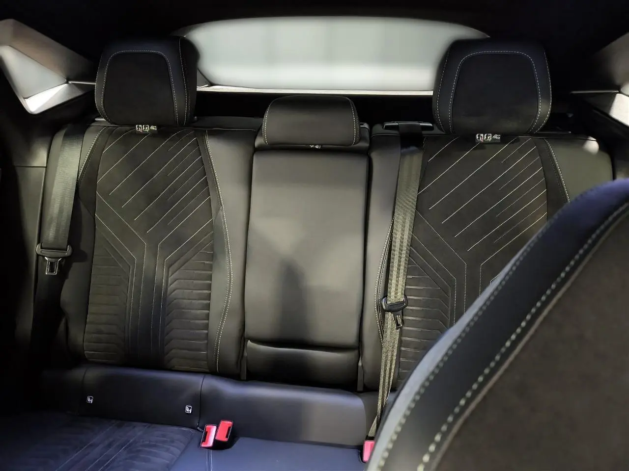 Vue intérieure des sièges arrière en Alcantara noir avec surpiqûres claires du Peugeot 3008 Hybrid 2025.