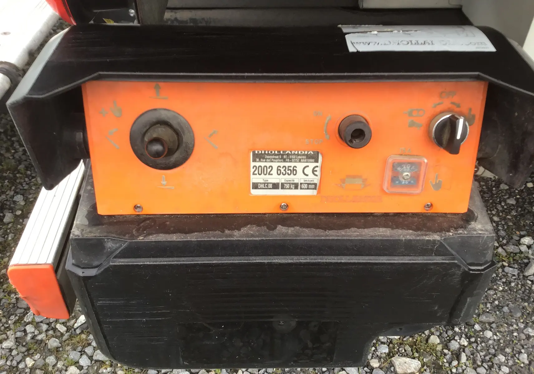 Gros plan sur le panneau de commande orange du hayon électrique arrière du fourgon blanc Opel Movano L3H1.