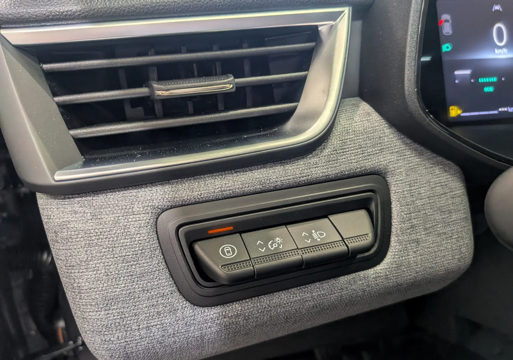 Détail intérieur côté gauche de la planche de bord gris tissu avec commandes d’éclairage et ventilation d’une Renault Clio V 2025.