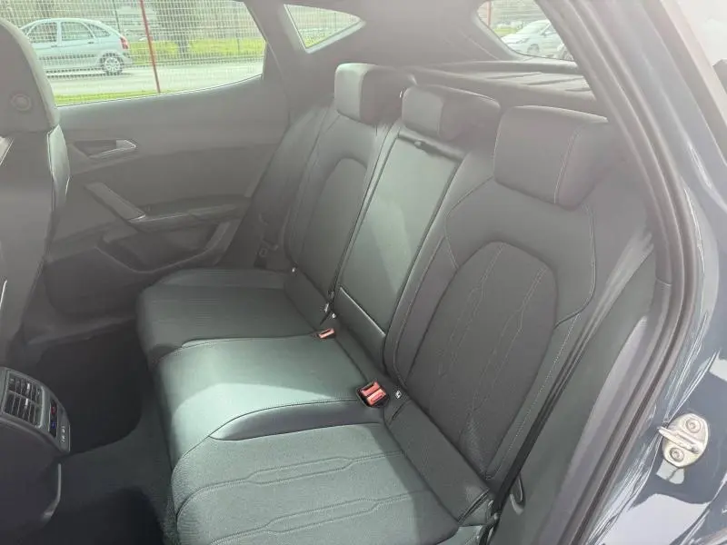 Vue intérieure côté arrière droit montrant la banquette arrière en textile noir du CUPRA Formentor bleu 2025.