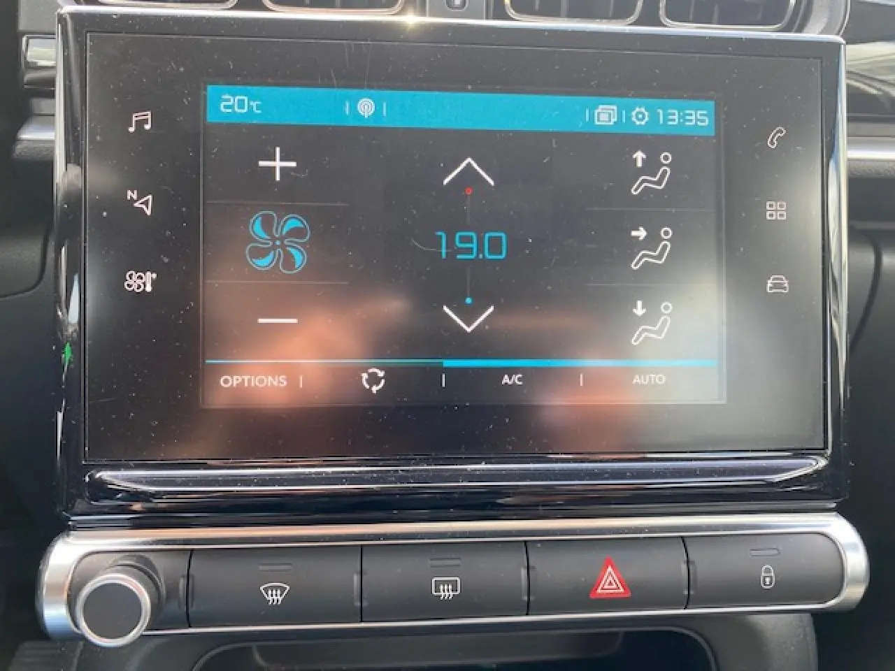 Écran tactile central de la Citroën C3 gris clair montrant la climatisation automatique à 19°C, vue de face.
