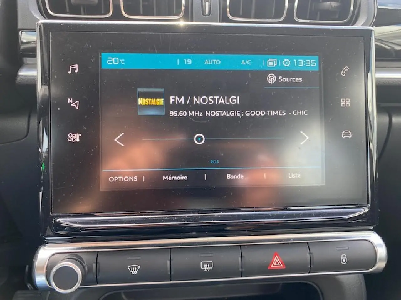 Vue rapprochée de l'écran tactile central du tableau de bord de la Citroën C3 gris clair, affichant la radio FM.