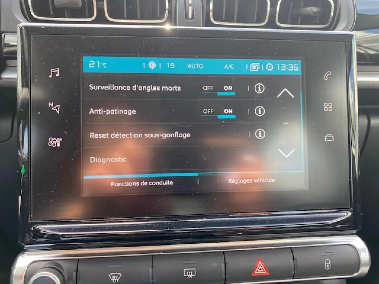 Écran tactile central de la Citroën C3 gris clair affichant les réglages de conduite avec surveillance d'angles morts activée.