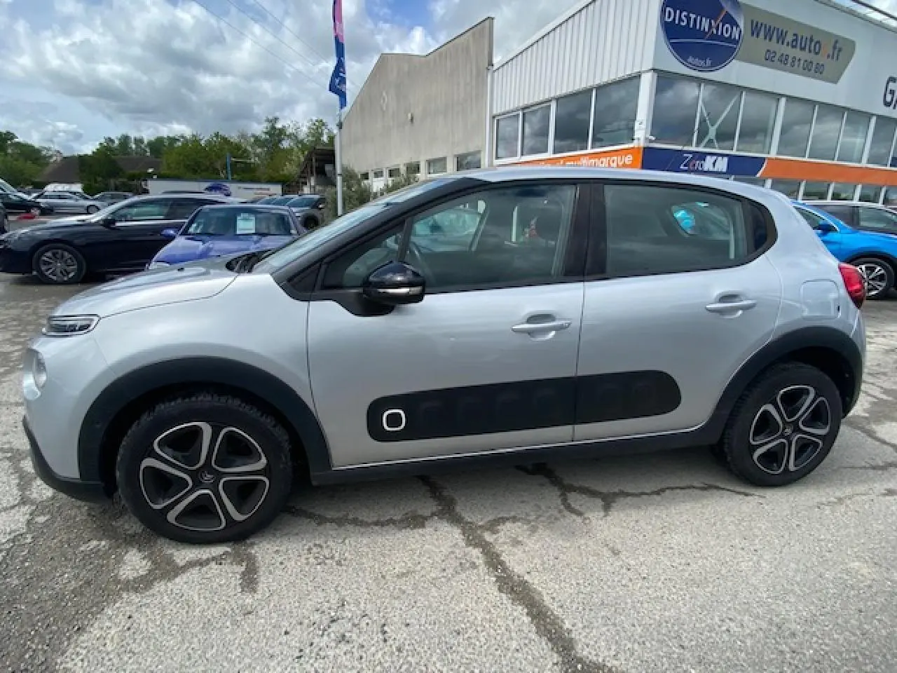 Profil côté gauche d'une Citroën C3 gris clair avec protections latérales noires et jantes 16 pouces en alliage.
