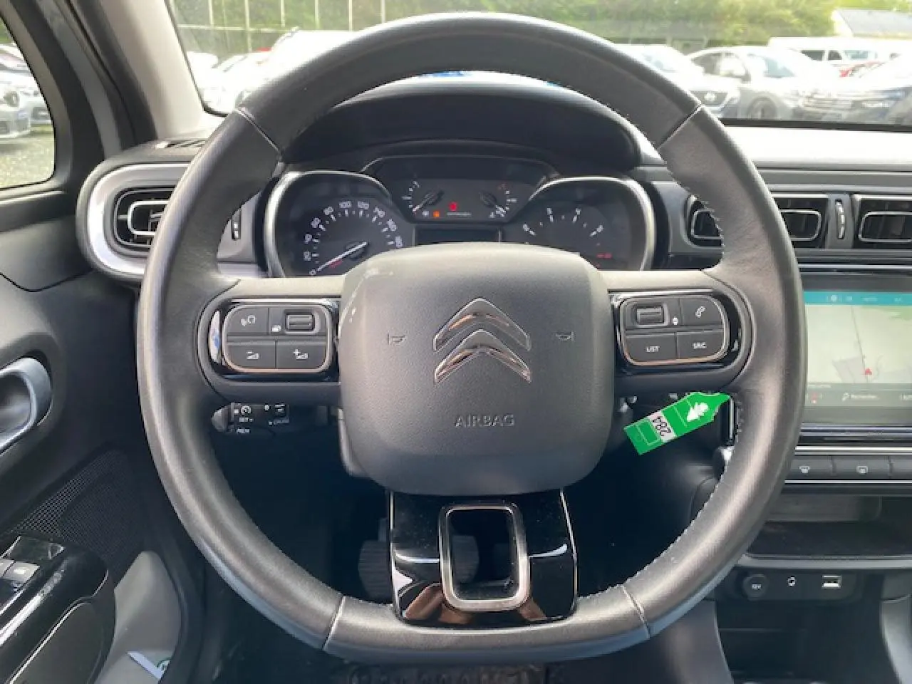 Vue frontale du volant noir de la Citroën C3 2017 avec commandes intégrées et tableau de bord visible.