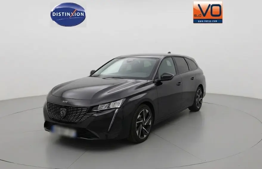 Peugeot 308 SW Hybrid noir vue 3/4 avant droit, avec calandre distinctive et phares LED fins.