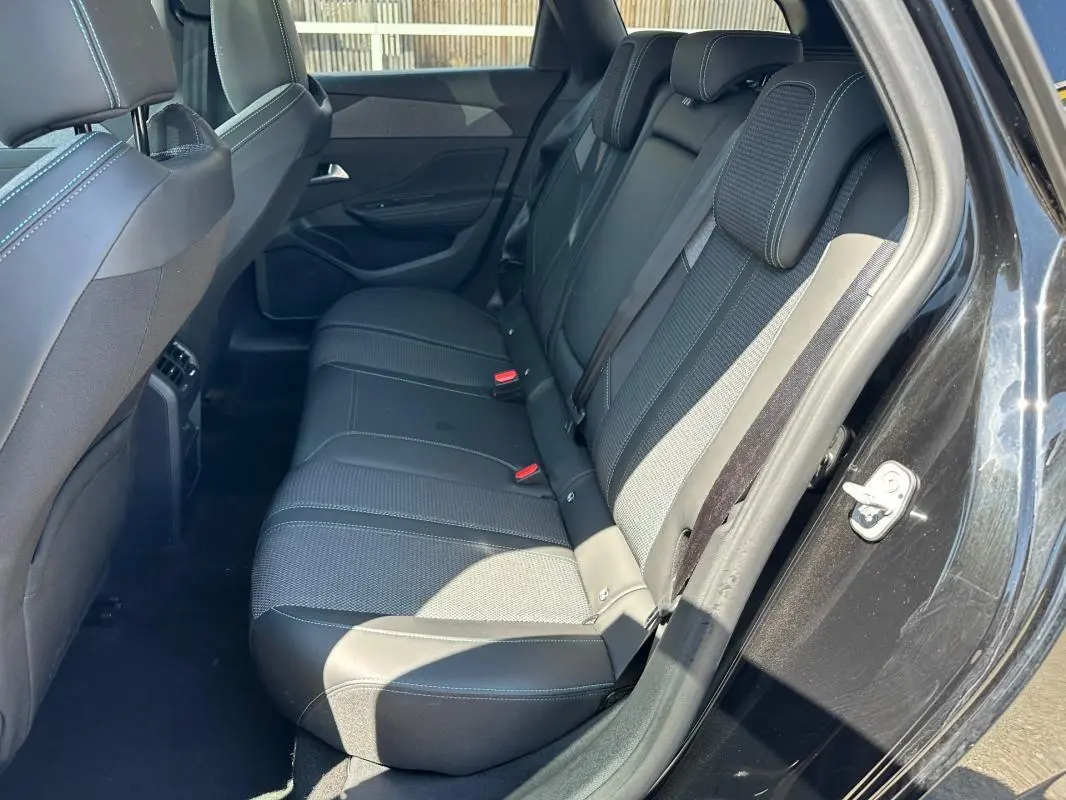 Vue côté droit des sièges arrière noirs en tissu et cuir du Peugeot 308 SW Hybrid 145 e-DCS6 Allure 2025.