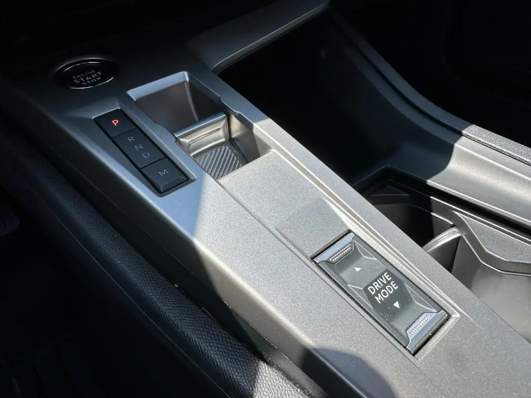Gros plan sur la console centrale argentée du Peugeot 308 SW Hybrid 145, avec boutons de boîte auto et mode de conduite.