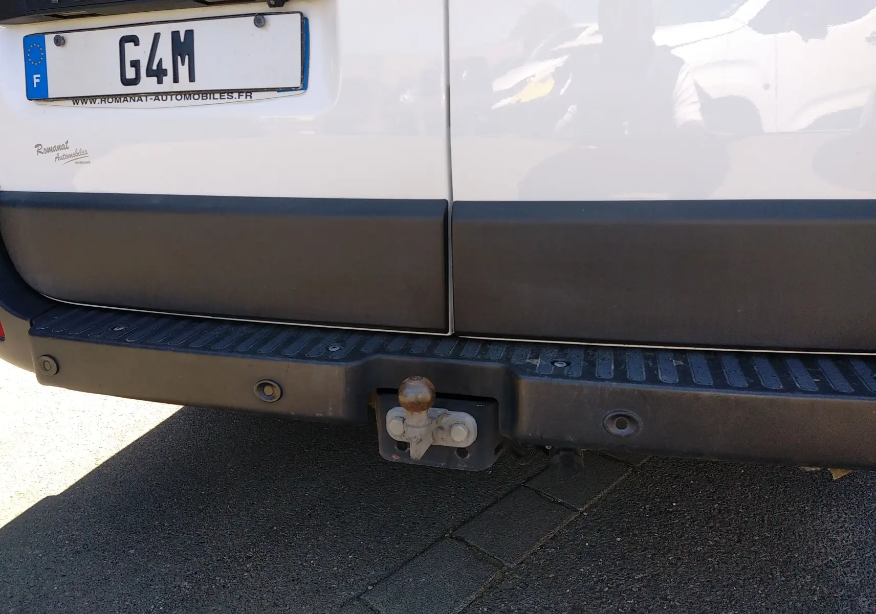 Vue rapprochée de l'arrière blanc du Renault Master III avec attelage et pare-chocs noir.