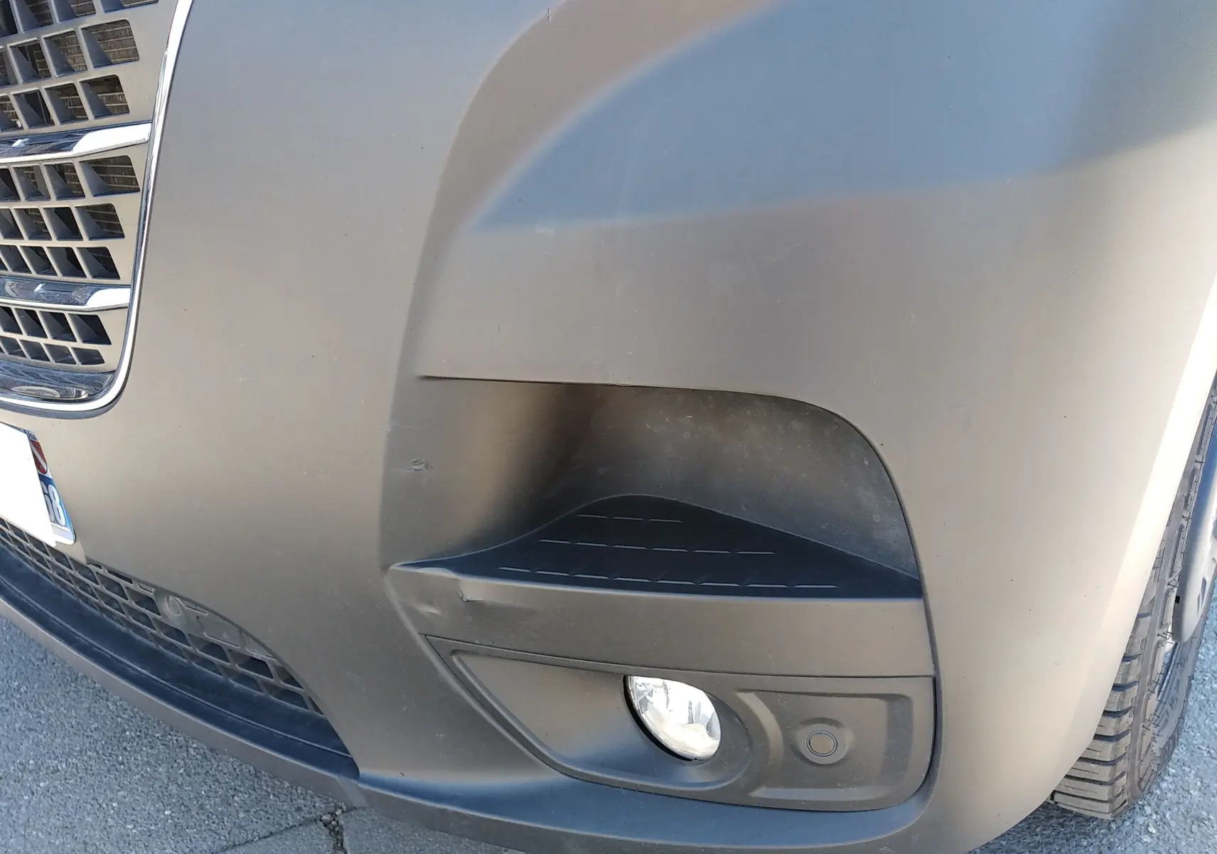 Gros plan sur le pare-chocs avant droit blanc du Renault Master III avec antibrouillard et capteur de stationnement.