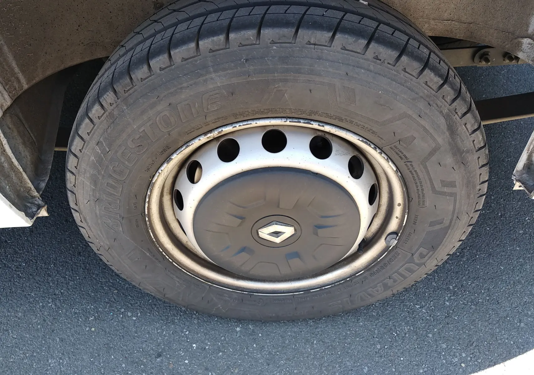 Gros plan sur la roue avant gauche d’un Renault Master blanc, avec jante acier et logo Renault au centre du cache-moyeu.