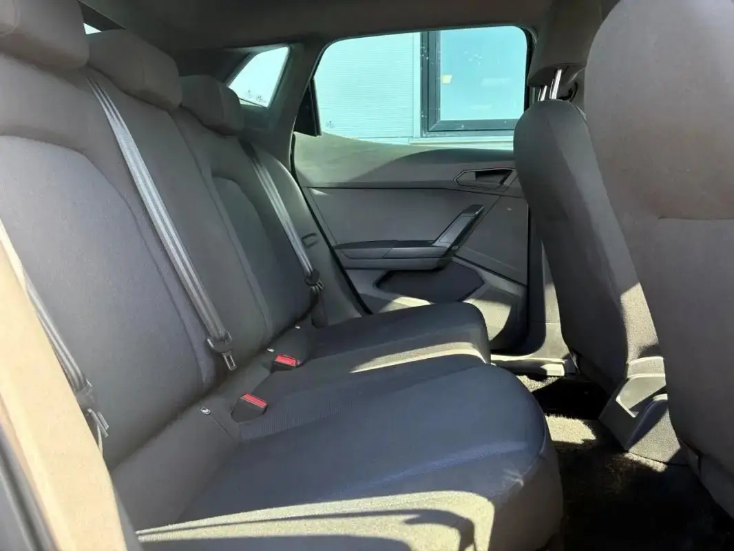 Vue intérieure côté droit des sièges arrière noirs d'une SEAT Ibiza 1.0 TSI 95 FR avec ceintures visibles.