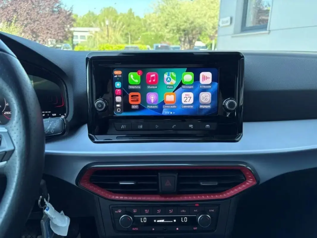 Vue intérieure centrée sur l’écran tactile multimédia de la SEAT Ibiza 2025 avec tableau de bord noir et détails rouges.