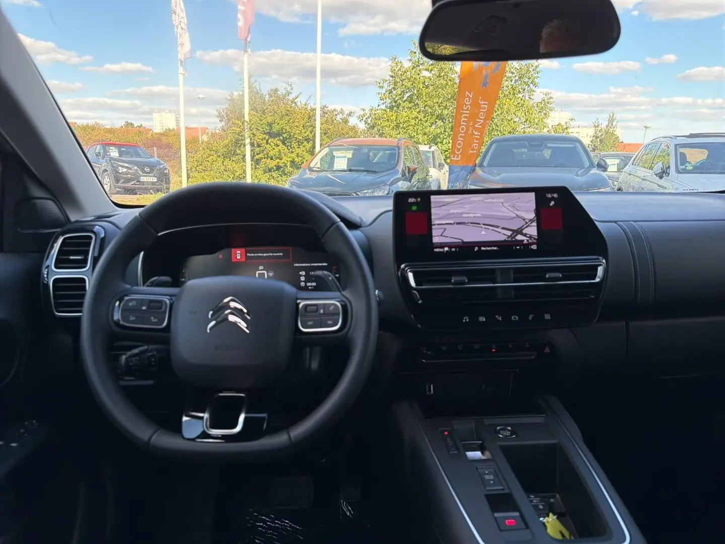 Vue intérieure du poste de conduite du Citroën C5 Aircross blanc 2025, avec écran tactile et volant multifonction.