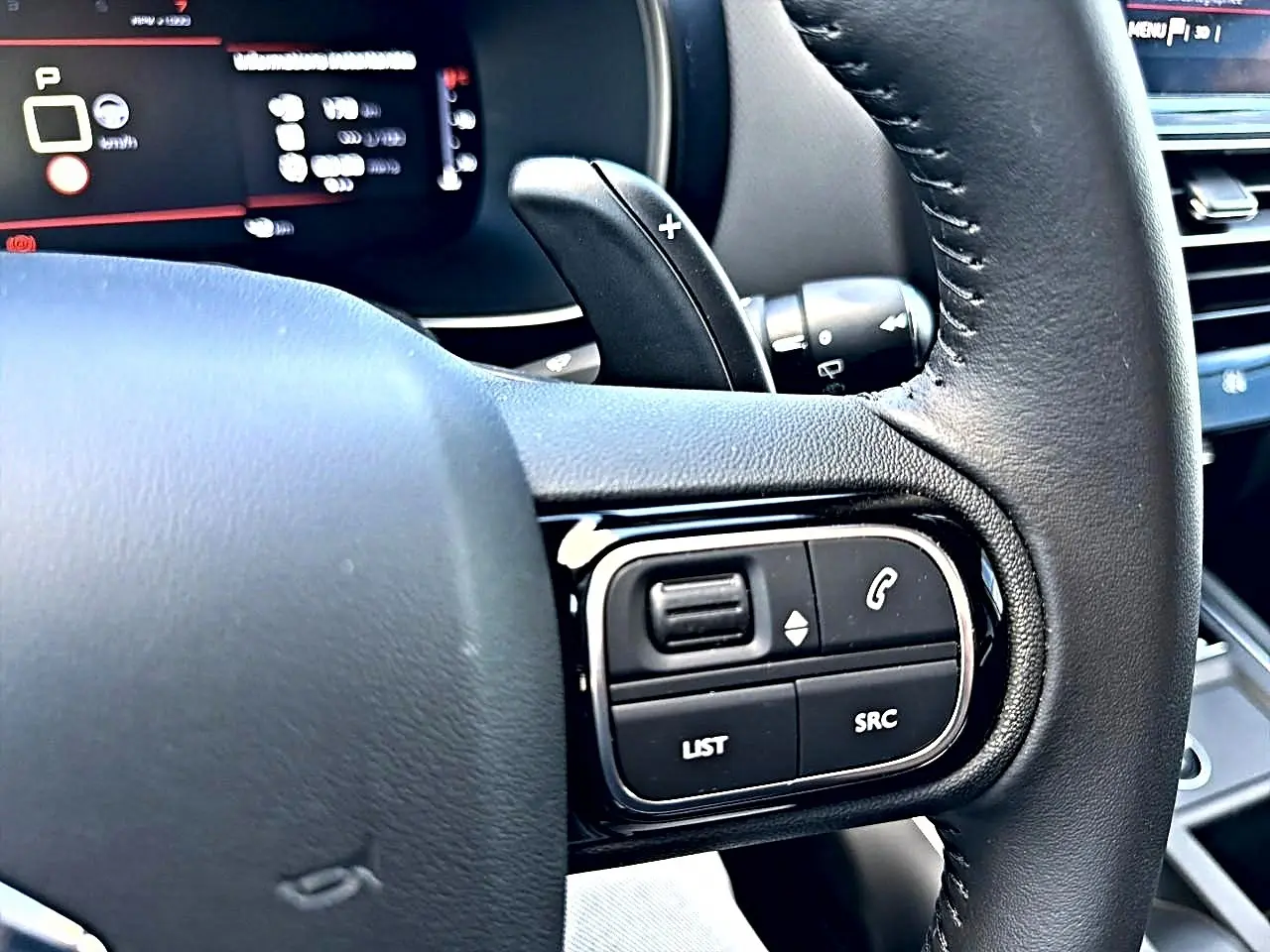 Gros plan sur le volant cuir noir côté gauche du Citroën C5 Aircross avec commandes multifonctions visibles.