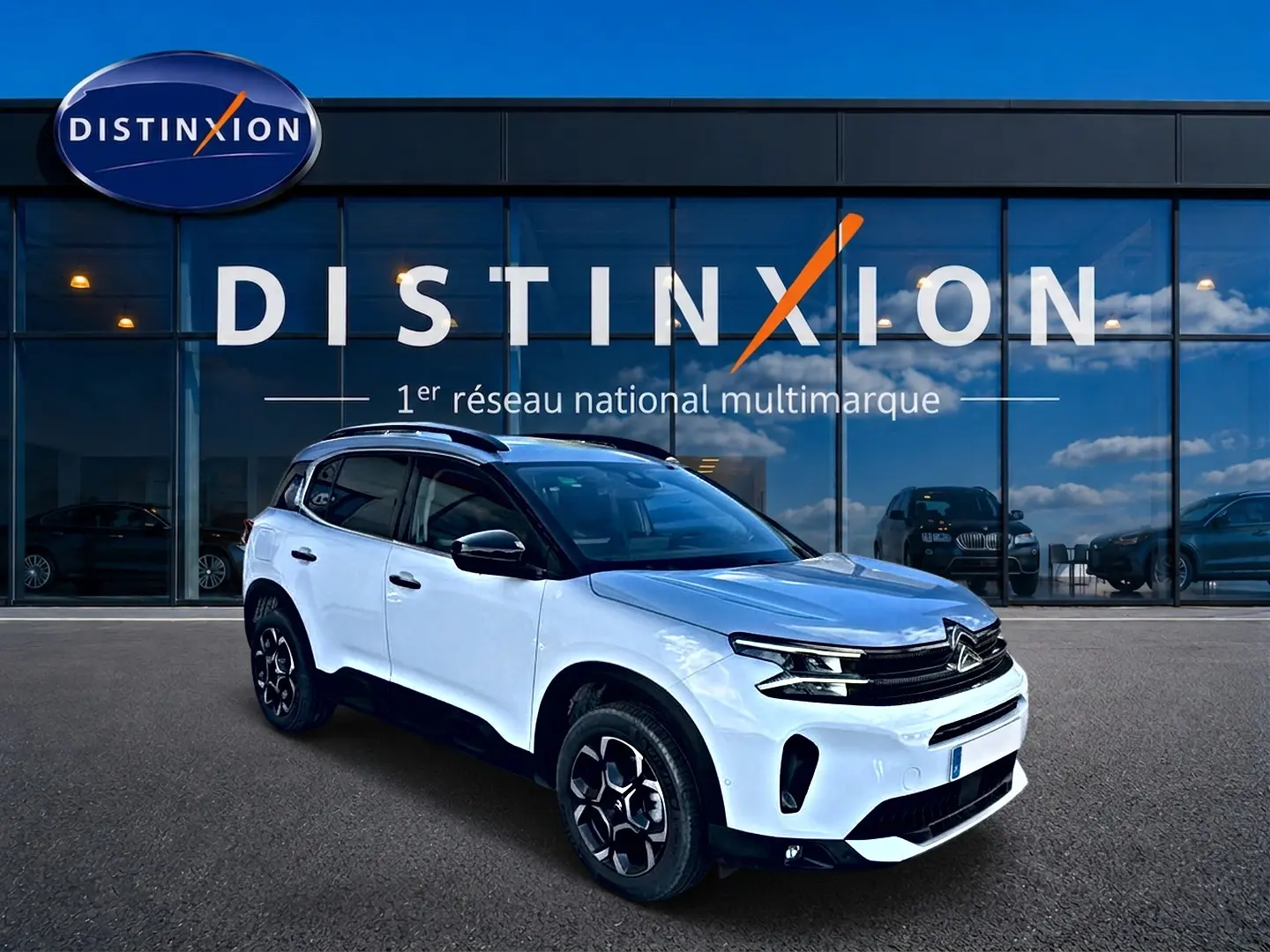 Citroën C5 Aircross blanc vue 3/4 avant droit, avec toit noir et jantes alu noires devant showroom Distinxion.