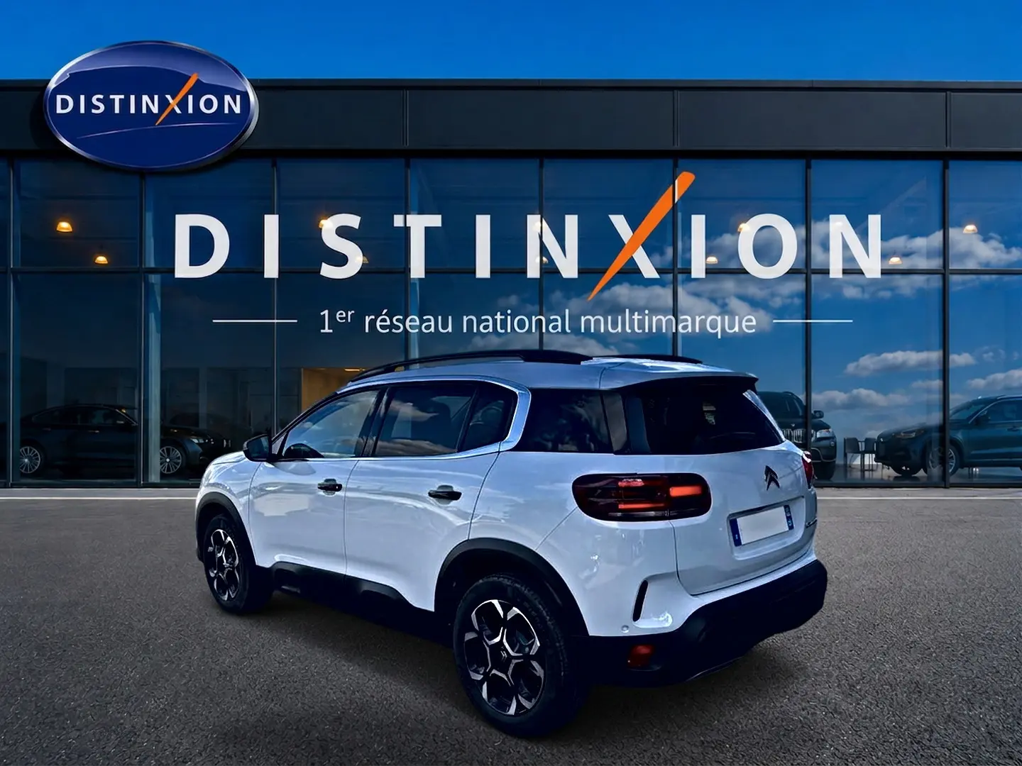 Citroën C5 Aircross blanc vue 3/4 arrière droit avec toit noir et jantes alu noires devant showroom Distinxion.