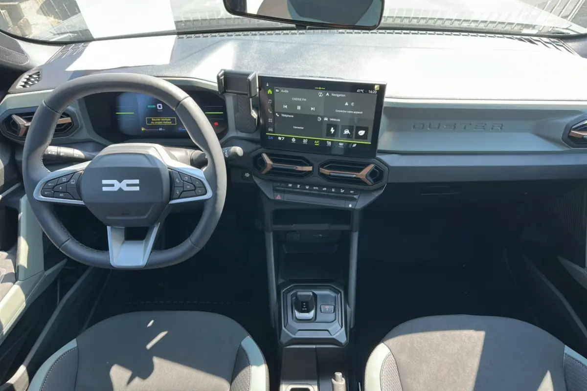 Vue intérieure du tableau de bord du Dacia Duster HEV 140 Extreme Pack Hiver 2025 avec écran tactile et volant multifonction.
