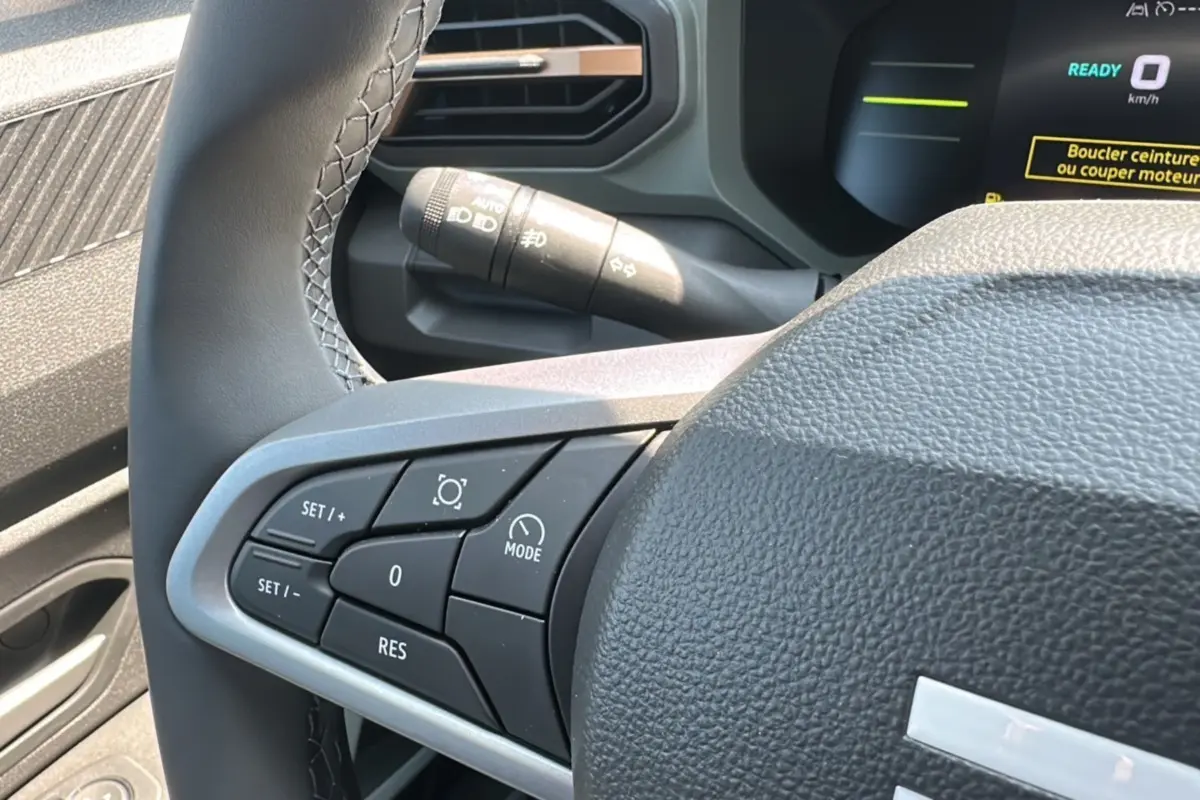 Vue rapprochée du volant du Dacia Duster HEV 140 Extreme Pack Hiver 2025, montrant les commandes côté gauche.