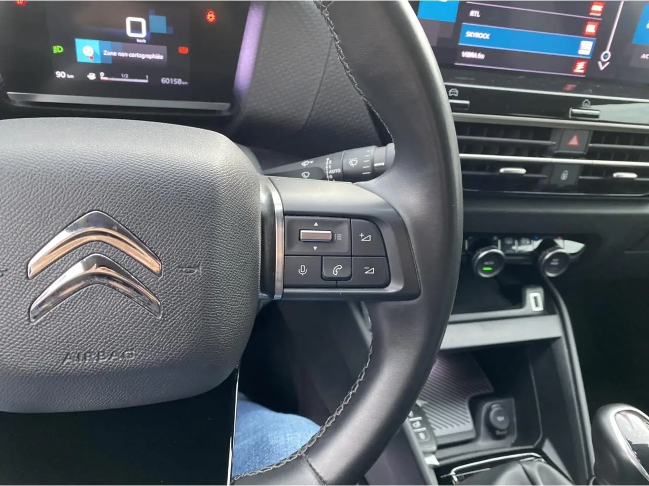 Vue rapprochée du volant et tableau de bord noir de la Citroën C4 2021 avec commandes multifonctions et écran tactile.