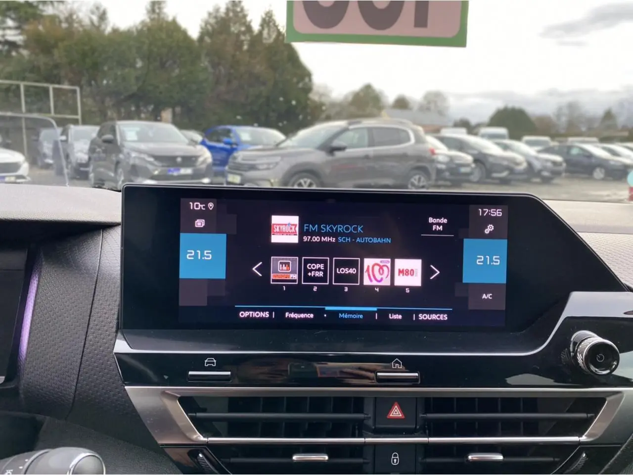Vue intérieure centrée sur l’écran tactile du tableau de bord de la Citroën C4 2021, avec affichage radio FM et commandes climatisation.