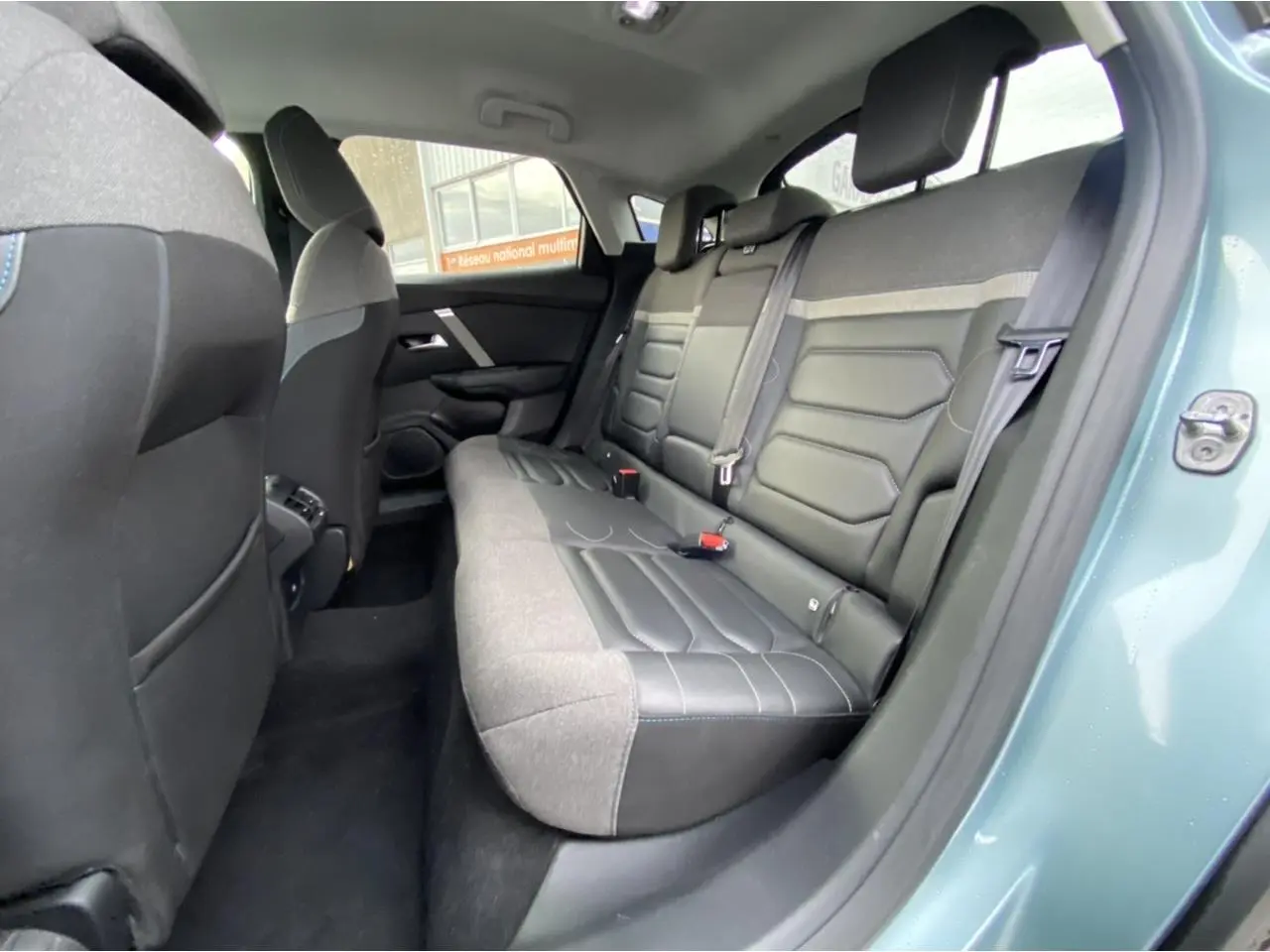 Vue intérieure côté arrière droit du Citroën C4 bleu Iceland montrant la banquette arrière en tissu et cuir noir.