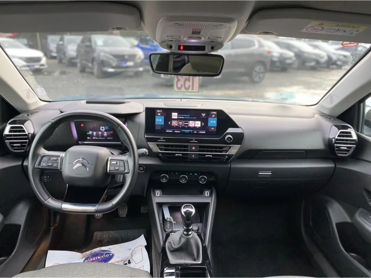 Vue intérieure avant du tableau de bord de la Citroën C4 2021, avec volant, écran tactile et levier de vitesses manuel.