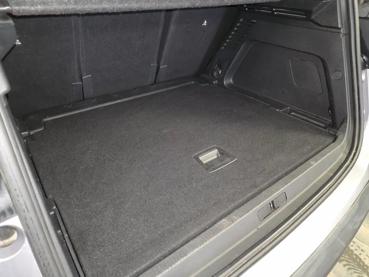 Coffre ouvert vu de l'arrière du Citroën C5 Aircross gris, montrant la surface de chargement plate et noire.
