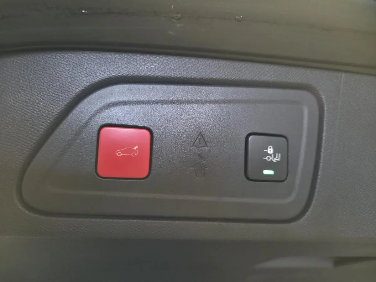 Gros plan sur les boutons de commande du hayon électrique et de verrouillage dans un Citroën C5 Aircross gris.